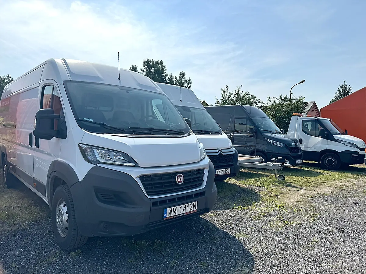 Rząd busów dostawczych Justom zaparkowanych na placu