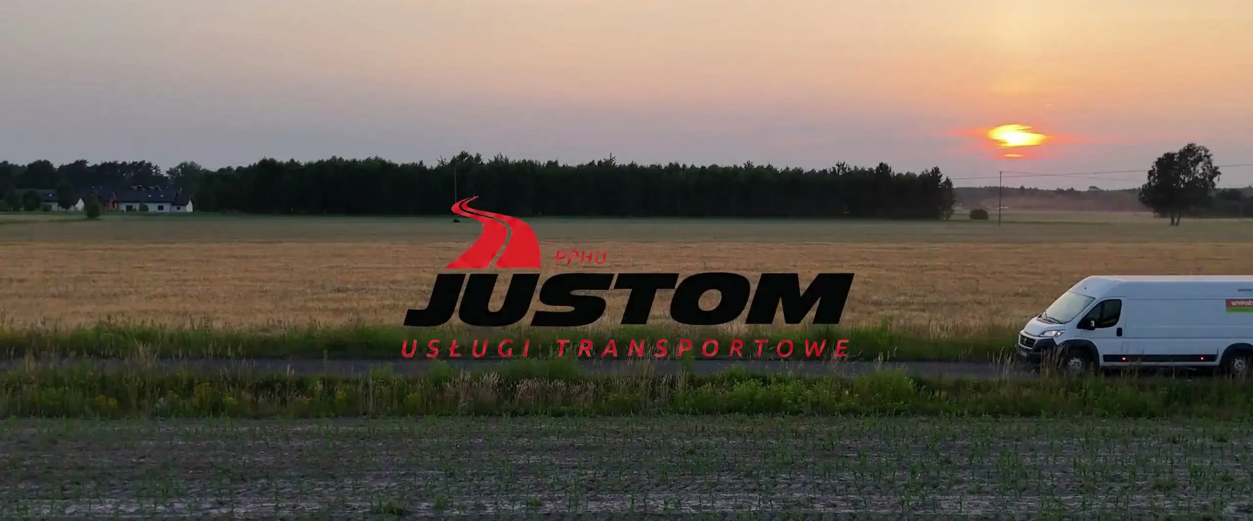 Dron nad trasą z białym busem Justom o zachodzie słońca