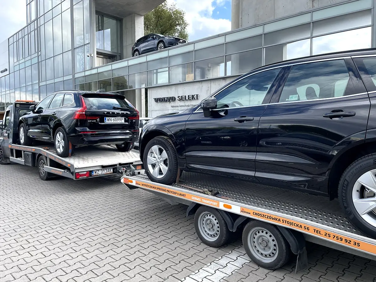 Czarne SUV-y Volvo na lawecie przed salonem samochodowym
